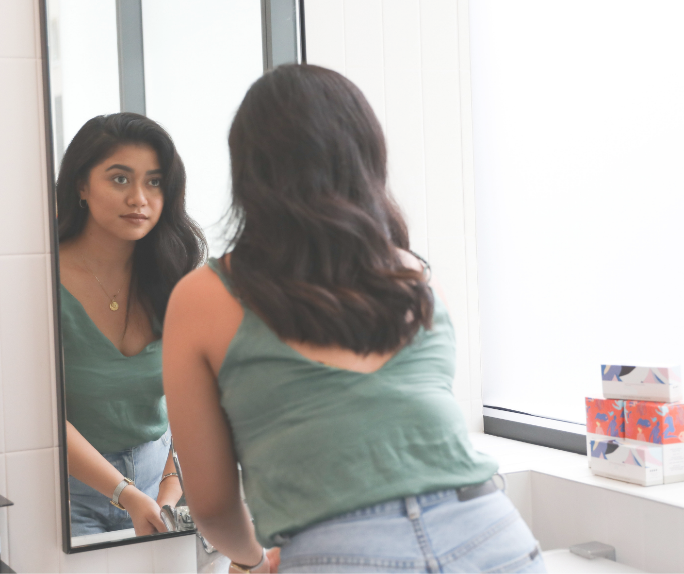 Person looks in the mirror while washing hands