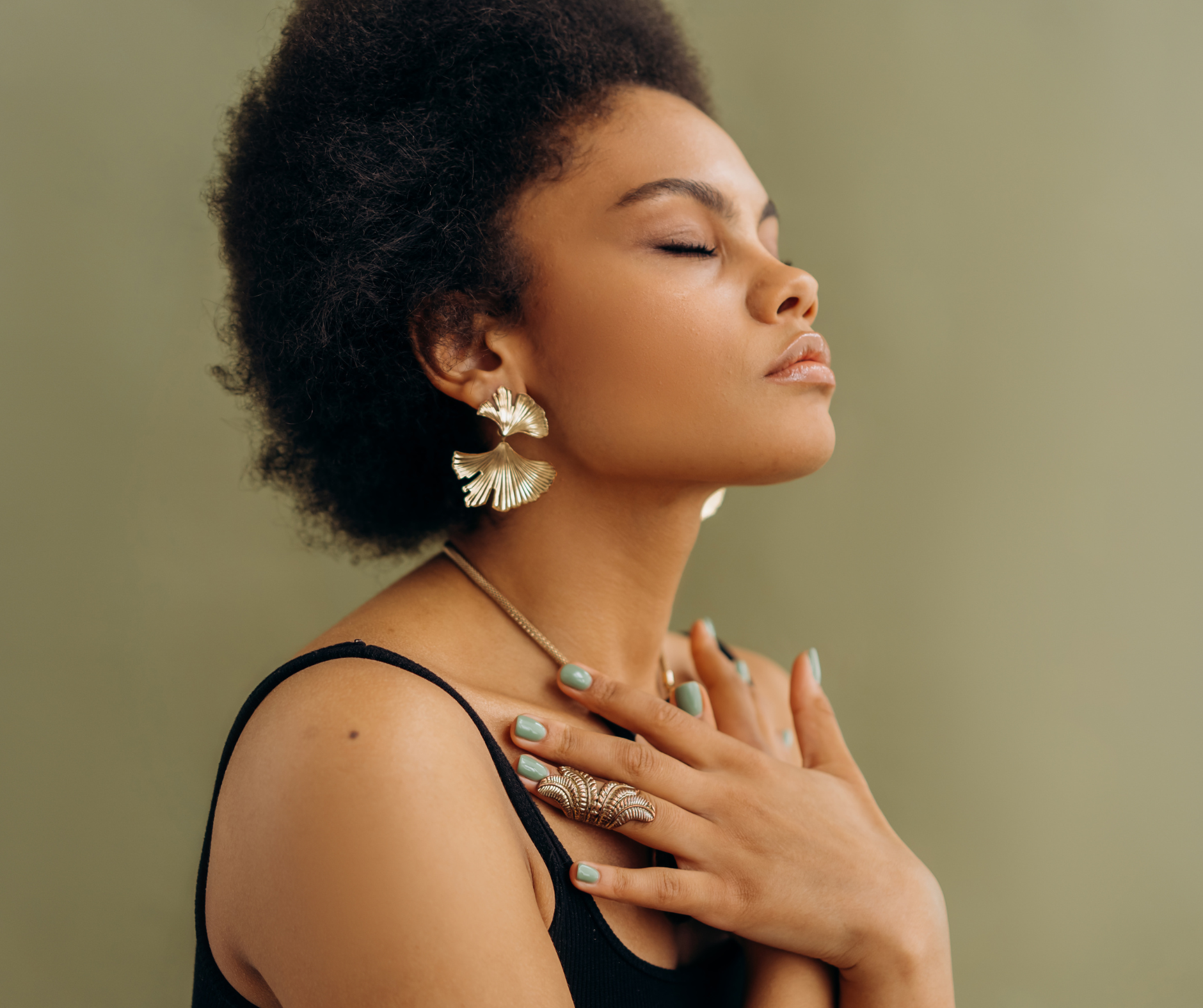 Person sits with eye closed and arms crossed in front of chest in quiet contemplation