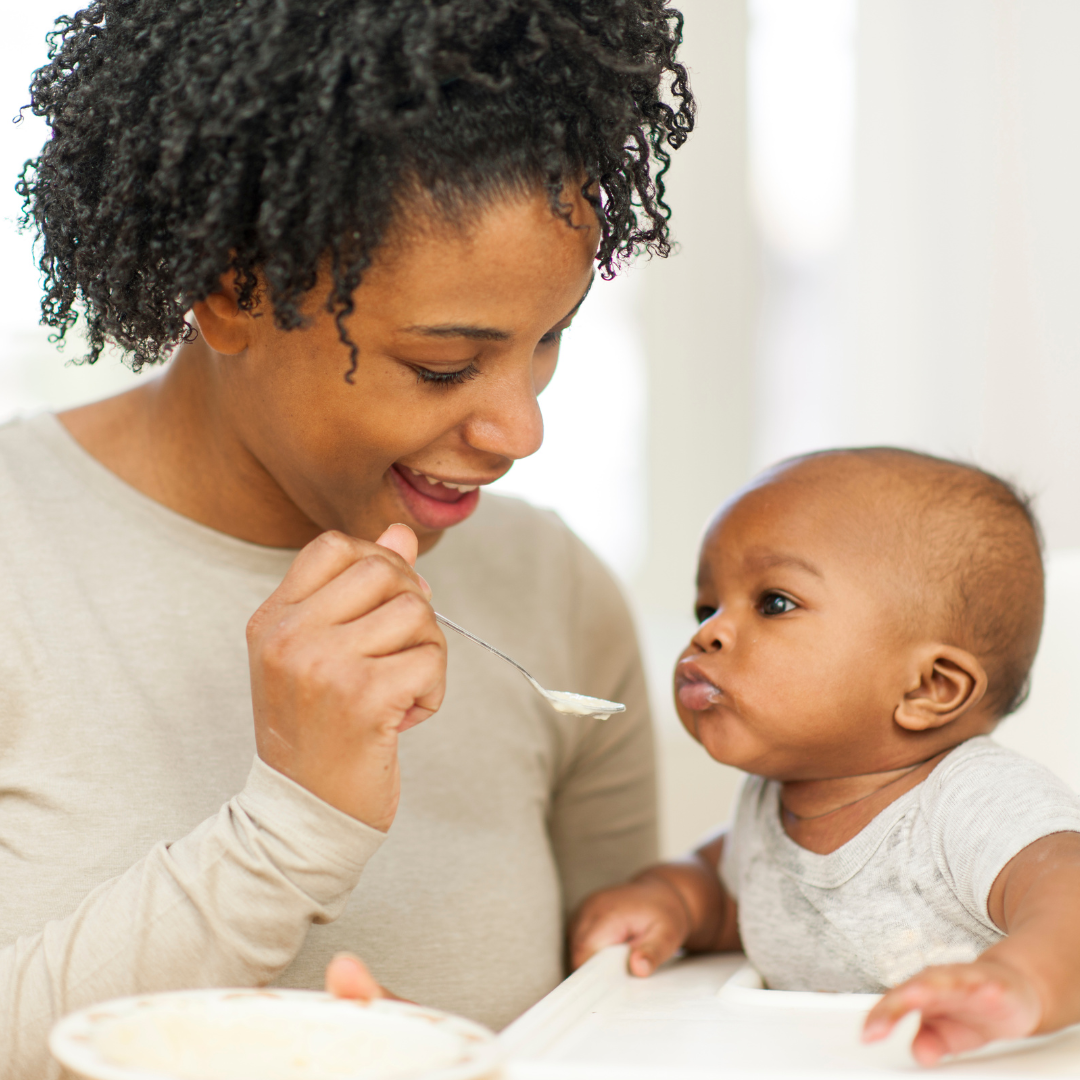 An adult gently feeds formula to an infant, demonstrating safe and responsive feeding practices.