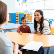 Educator talking to a parent and child in a classroom