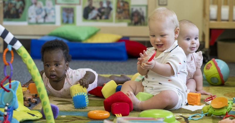 Infants playing on a mat