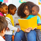 Children reading a book with and educator